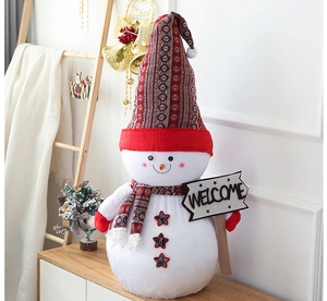 Detail of giant plush Christmas snowman with red knit hat holding a Welcome sign