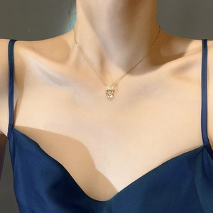 Elegant gold plated crown pendant necklace with dancing stone worn by female model