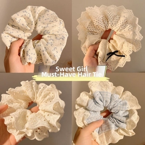 Close-up of assorted floral and lace scrunchies showing fabric textures and patterns