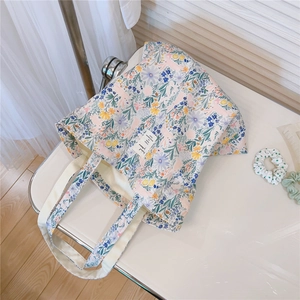 Detail shot of canvas tote bag featuring floral print and woven decorative label