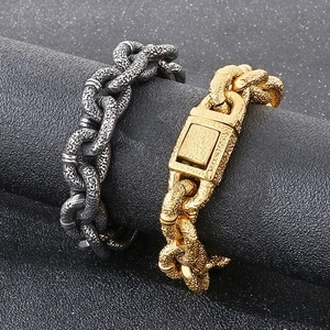Detail of chunky gold and antique silver bracelets with hammered texture on black pillar