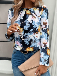 Detail of casual long-sleeved floral blouse with round neck and vibrant blue floral print