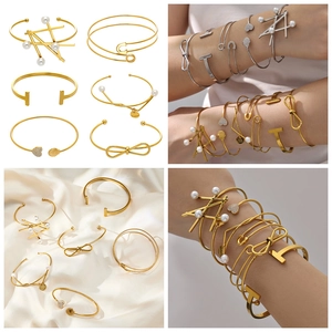 Detailed shot of 18k gold-plated geometric bangles with pearls and good lucky charm