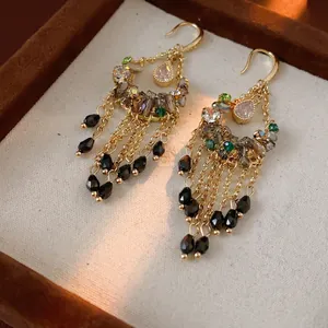 Vintage gold tassel earrings with pink teardrop gems and zircon stones on brown velvet