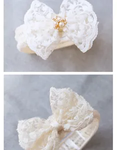 Macro shot of white lace baby headband with pearl and rhinestone bow embellishment