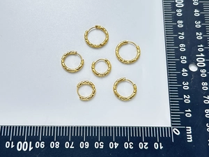 Macro view of three pairs of hammered texture 18K gold plated hoop earrings with size ruler