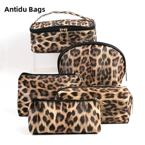 Detailed view of 5-piece leopard print makeup bag set with gold zippers and top handle