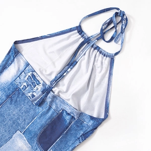 Detail of the halter neck tie and denim print pattern on the blue backless mini dress