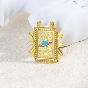 Detail of gold tarot pendant with blue enamel Saturn motif and sparkling cubic zirconia stones