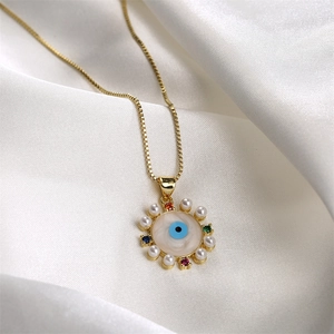 Collana malocchio dorata con zirconi colorati e perle su seta bianca liscia