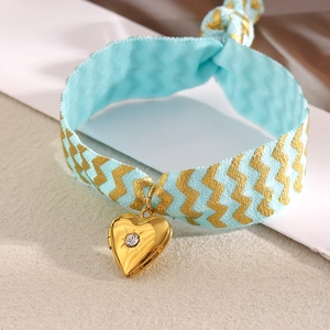 Blue wavy fabric bracelet with 18K gold heart pendant and single zircon stone