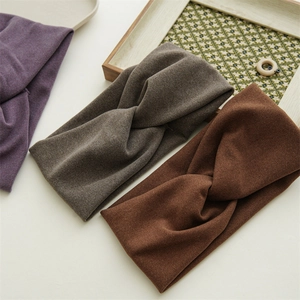 Three winter knitted headbands in purple, taupe, and brown with stylish cross-knot design