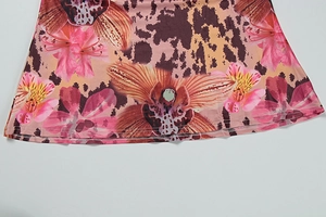 Detailed close-up of hemline with floral orchid and leopard print on knit fabric
