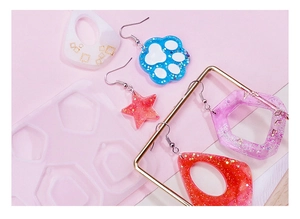 Detailed view of DIY resin earring molds with colorful glitter cat paw and star pendants