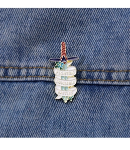 Close-up of enamel sword pin with Fighting Invisible Battles text on denim jacket
