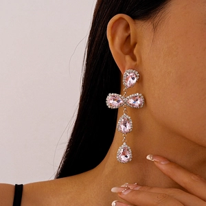 Detailed view of pink teardrop crystal tassel earrings on model showing silver finish