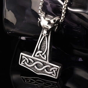 Vue macro du pendentif Mjolnir Viking en argent vintage avec relief de chèvre et reflet