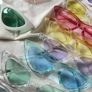 Flat lay of colorful candy-colored cat eye sunglasses on a white textured fabric background