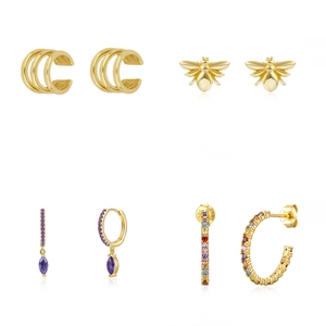 Detail of gold-plated earring set featuring colorful zircons and a small bee stud