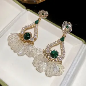 Elegant emerald teardrop earrings with white pearls and iridescent flower petals