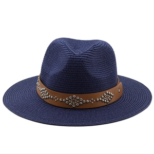 Close-up of navy straw fedora featuring a brown leather band with silver rivets