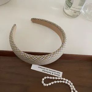 Detailed view of British vintage beige plaid fabric headband on a stylish wooden tray