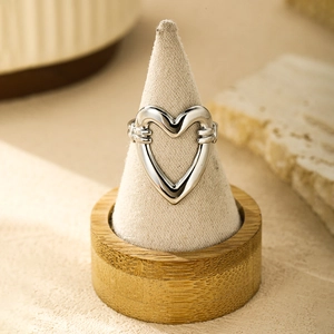 Detailed view of silver hollow heart ring on a velvet display cone with natural light