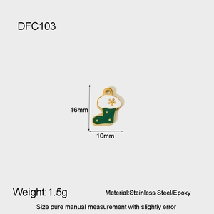 Detail of a gold stainless steel Christmas stocking charm with green enamel and star