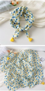 Detail of fruit print scarf featuring blue berry patterns and vibrant yellow tassels