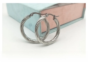 Close-up of silver twisted rope texture on stainless steel hoop earrings with clasp