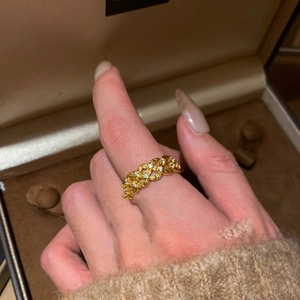 Gold plated criss-cross hollow ring with cubic zirconia stones shown on finger