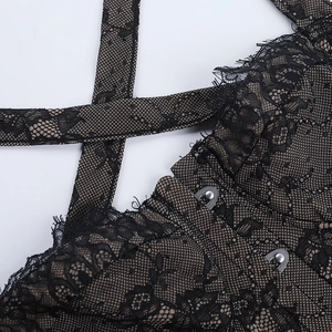 Close-up of black floral lace fabric with metal hook fasteners and mesh lining details