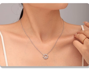 Gros plan du collier tournesol argenté avec pendentif en zircon sur la clavicule féminine