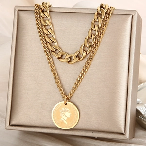 Detail of gold double-layered chunky chain necklace with queen portrait coin pendant