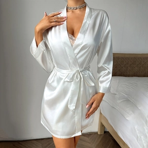 Elegant white satin robe for women with belt and tassel details in a bedroom setting