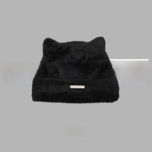 Detailed close-up of a black faux mink fur knit hat with cute cat ears and metal logo tag