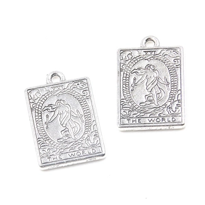 Macro shot of silver zinc alloy tarot charms featuring The World relief design