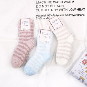 Detail von flauschigen Wintersocken mit Fluffy Winter Etiketten auf weißem Stoff