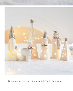 Close-up of ceramic Christmas figurines with glowing warm light and gold star details