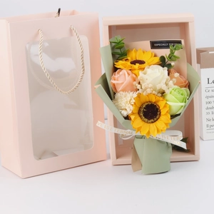 Detail of pink gift box with artificial roses, sunflowers and carnations bouquet