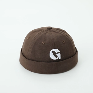 Detailed embroidery of letter G on brown brimless hat with reinforced stitching