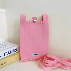 Detailed view of pink knitted phone bag featuring a metal buckle and woven strap