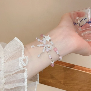 Sweet pink and white double-layer beaded bracelet with star and bow charms on wrist