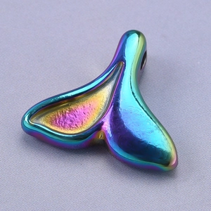 Macro shot of 18k vacuum plated iridescent rainbow metal whale tail pendant charm
