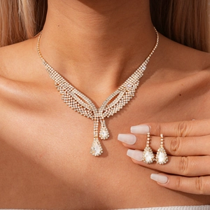 Elegant two-piece gold jewelry set with teardrop crystals and sparkling diamonds for women