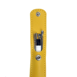 Detail of yellow leather case with stainless steel ear pick set and cleaning brush tools