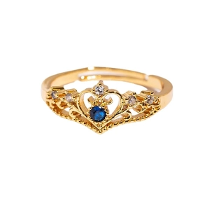 Golden crown ring featuring a blue gemstone and clear zircons with adjustable open band