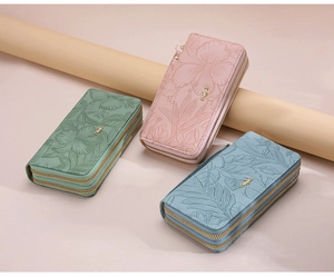 Macro view of floral embossed texture and dual zipper detail on women's long wallets