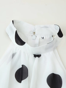 Detailansicht des weißen Polka-Dot-Halterneck-Tops mit Knopf und Reißverschluss hinten