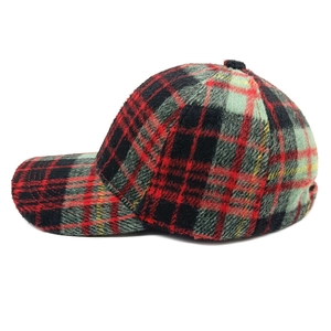 Detail of red and black plaid wool baseball cap showing textured fabric and curved brim